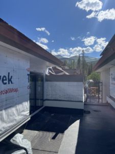 Peaks 8 and 9 in the background with a new roof and insulation wrap on the building in the foreground.