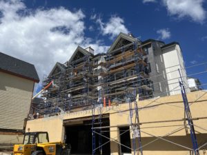 The south side of the tower building still has scaffolding on it but the siding, windows, balcony railings, and doors are all installed and the paint is nearly complete.