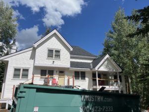 The front of two of the lower townhomes is shown with fresh paint and balconies and doors under construction.