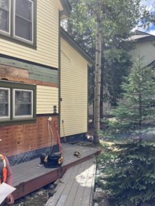 The side of one of the lower townhomes is shown with replacement of ice and water shield and siding.